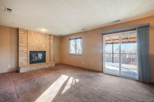 unfurnished living room featuring a fireplace, carpet, and a textured ceiling