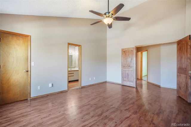 interior space with a textured ceiling, wood-type flooring, high vaulted ceiling, and ceiling fan