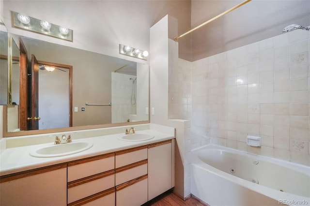 bathroom with tiled shower / bath and vanity