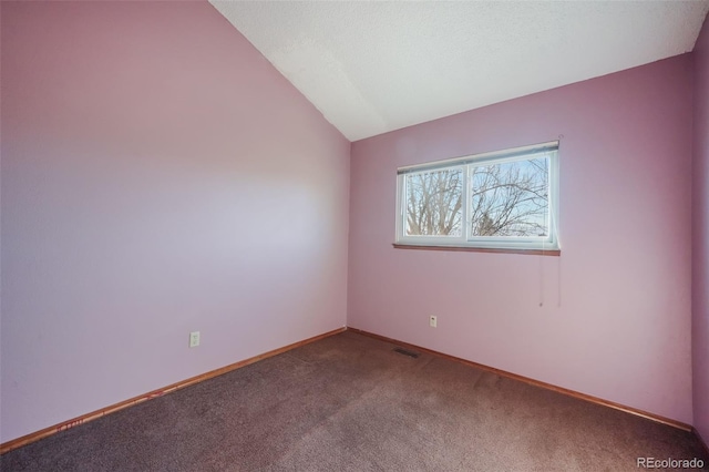 carpeted empty room with lofted ceiling and a textured ceiling