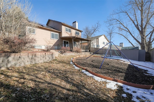 back of house with a playground, a porch, and a storage shed