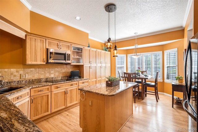 kitchen featuring black appliances, a textured ceiling, tasteful backsplash, crown molding, and dark stone countertops