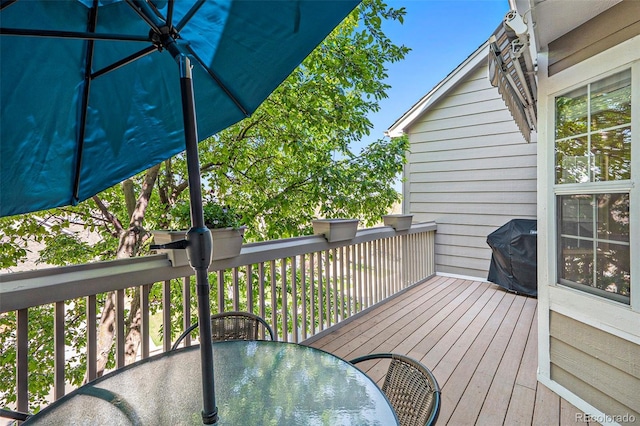 deck with outdoor dining space and grilling area