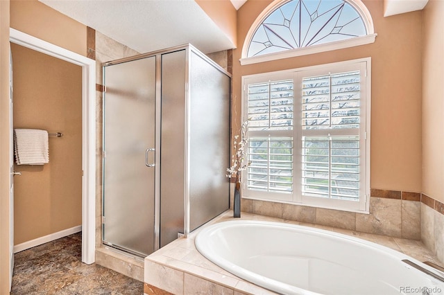 bathroom with a stall shower and a bath