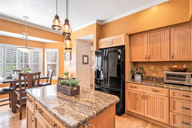 kitchen featuring black refrigerator with ice dispenser, a textured ceiling, light wood-style floors, decorative backsplash, and a center island