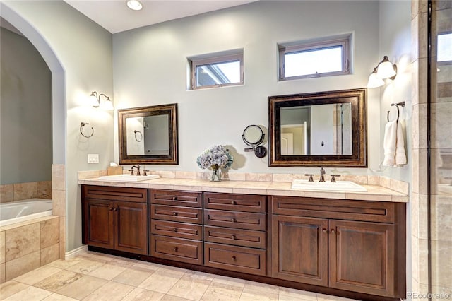 full bath featuring double vanity, a sink, and a bath