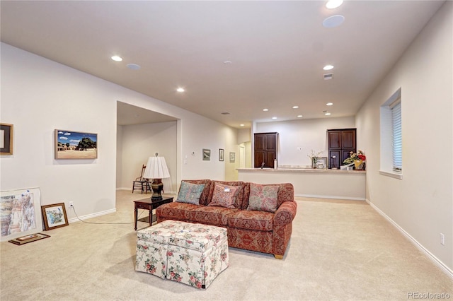 living area featuring recessed lighting, baseboards, and light colored carpet