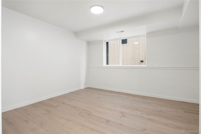 unfurnished room with wood finished floors, visible vents, and baseboards