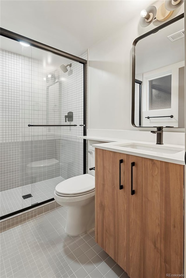 bathroom with toilet, visible vents, vanity, a shower stall, and tile patterned floors