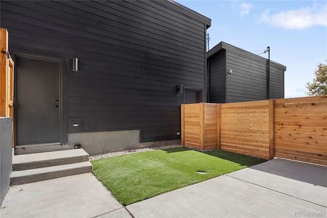 view of yard with entry steps, fence, and a patio