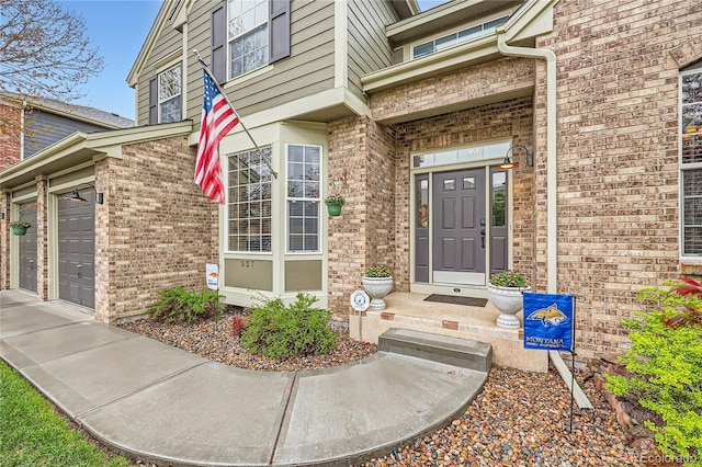 527 Stonemont Dr, Castle Pines, CO 80108 - doorway to property featuring brick siding, an attached garage, and driveway