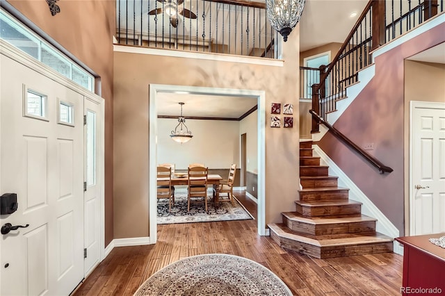 527 Stonemont Dr, Castle Pines, CO 80108 - foyer entrance with baseboards, stairway, a towering ceiling, wood finished floors, and ornamental molding