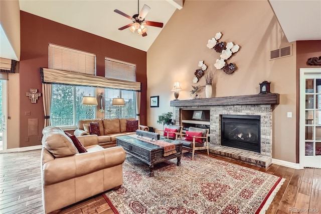 527 Stonemont Dr, Castle Pines, CO 80108 - living room with high vaulted ceiling, a ceiling fan, hardwood / wood-style floors, a brick fireplace, and beamed ceiling