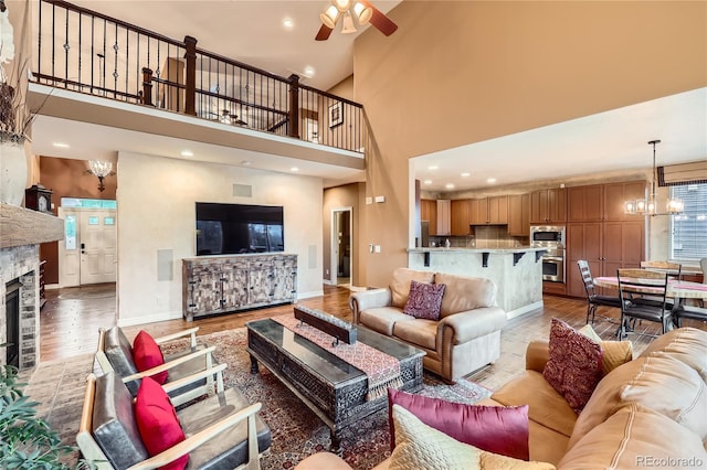 527 Stonemont Dr, Castle Pines, CO 80108 - living area with light wood-style floors, a chandelier, a towering ceiling, ceiling fan, and baseboards