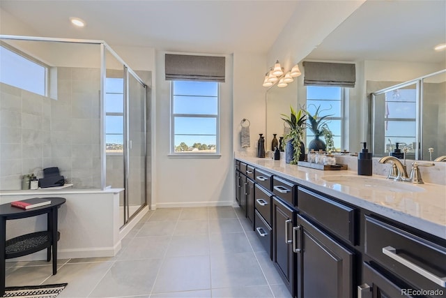 bathroom featuring a healthy amount of sunlight, a stall shower, and a sink