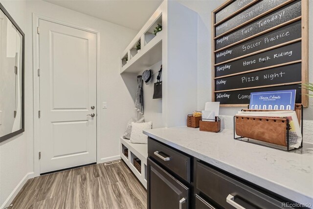 mudroom with baseboards and wood finished floors