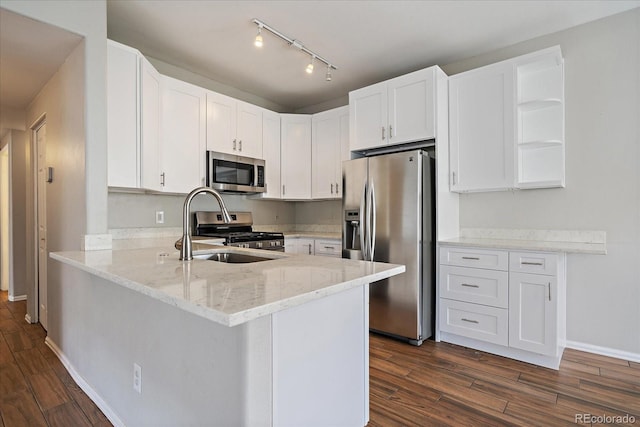 kitchen featuring appliances with stainless steel finishes, a sink, open shelves, dark wood-style flooring, and white cabinetry