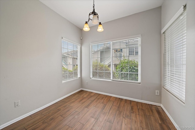 spare room featuring wood finished floors and baseboards