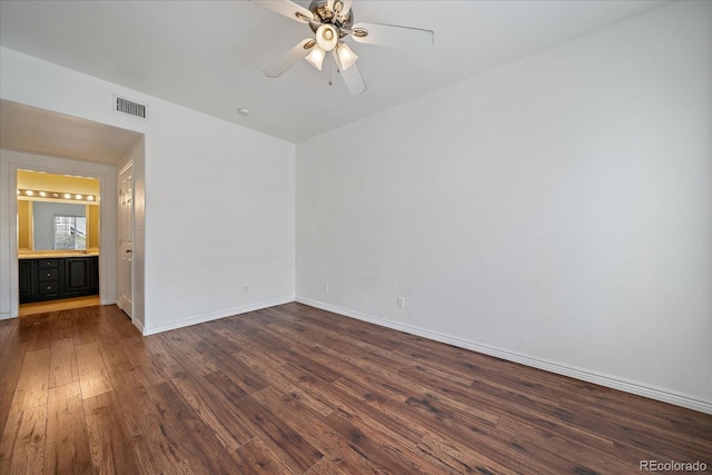 unfurnished room featuring dark wood-type flooring, a ceiling fan, and baseboards