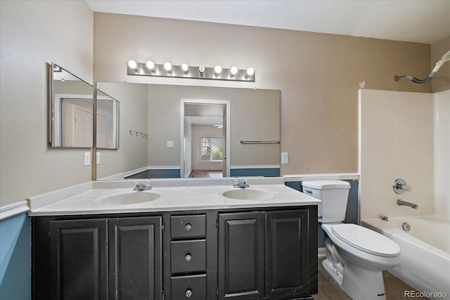 bathroom with double vanity, toilet, and  shower combination