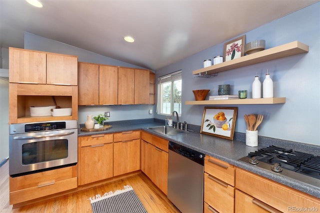 kitchen with lofted ceiling, sink, stainless steel appliances, and light hardwood / wood-style floors