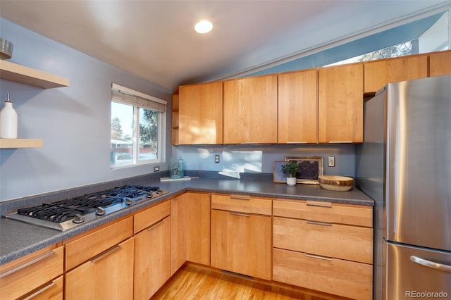 kitchen with lofted ceiling, light wood-type flooring, and appliances with stainless steel finishes