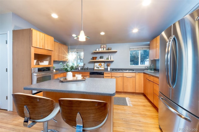 kitchen featuring light brown cabinetry, sink, a center island, light hardwood / wood-style flooring, and stainless steel appliances