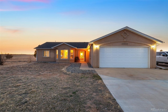 single story home featuring stucco siding, an attached garage, and driveway