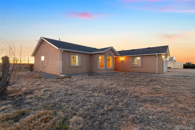 view of front of home featuring stucco siding and fence