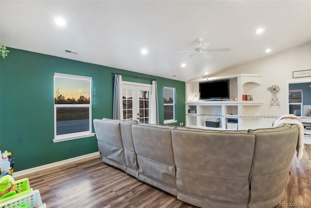 living area with visible vents, wood finished floors, french doors, baseboards, and vaulted ceiling