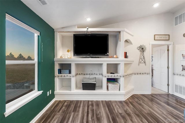 living room featuring vaulted ceiling, wood finished floors, and visible vents