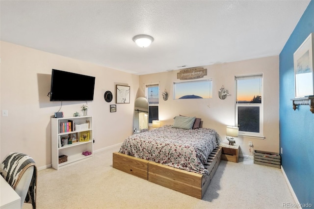 bedroom with baseboards, carpet floors, and a textured ceiling