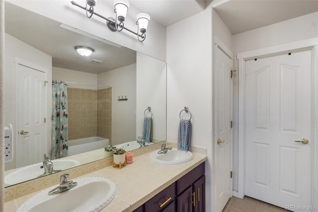 bathroom featuring tile patterned floors, double vanity, and a sink