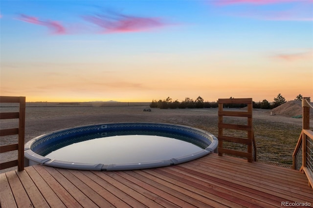 deck at dusk featuring a rural view