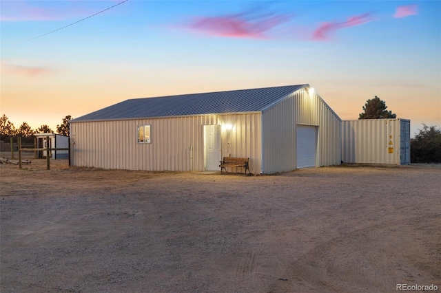 view of pole building with dirt driveway