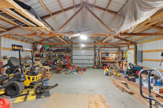 garage with electric panel, metal wall, and a workshop area