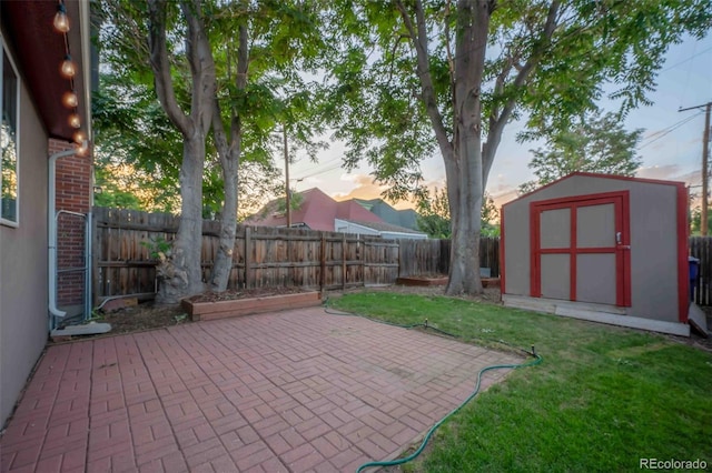 patio terrace at dusk featuring a shed and a yard