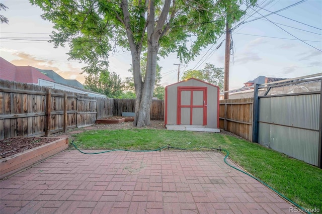 patio terrace at dusk featuring a yard and a storage unit