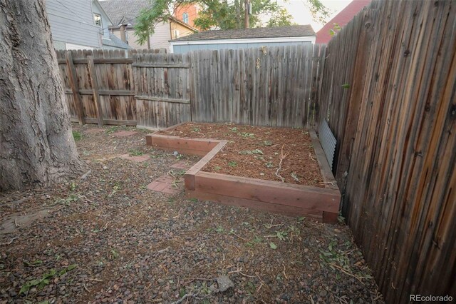 view of yard with a fenced backyard and a vegetable garden