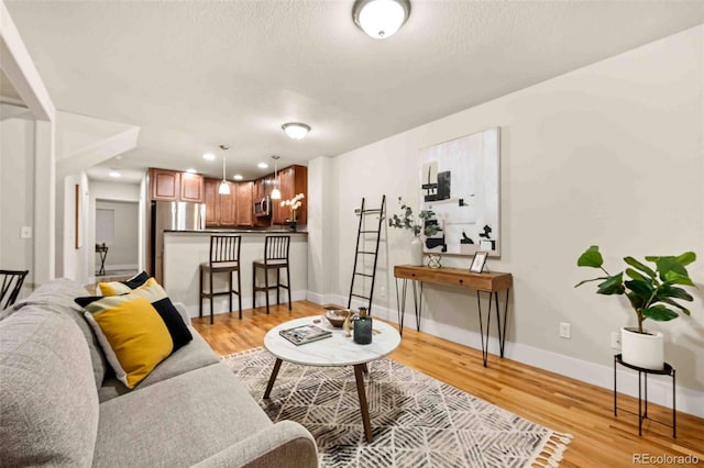 living room with light wood-type flooring and a textured ceiling