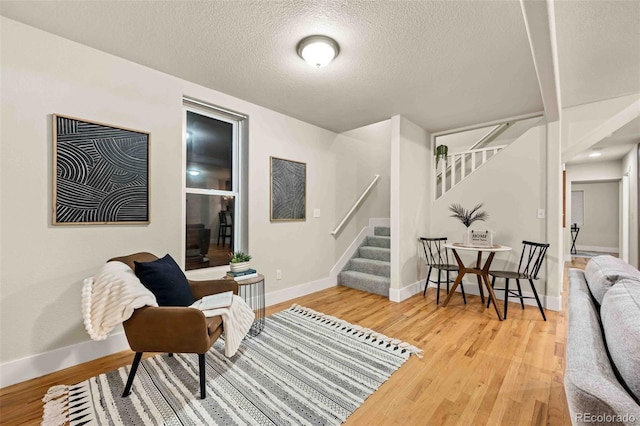 living area with hardwood / wood-style flooring and a textured ceiling