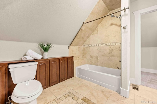 bathroom with vaulted ceiling, tiled shower / bath, and toilet