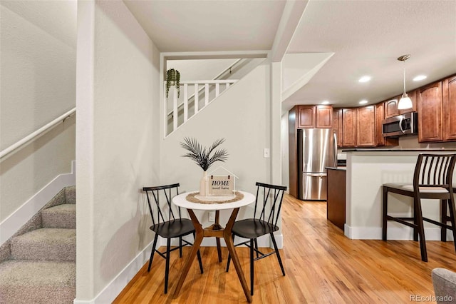 dining area featuring recessed lighting, baseboards, stairs, and light wood finished floors