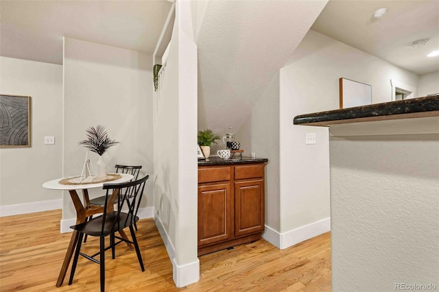 bar featuring light wood-type flooring and baseboards