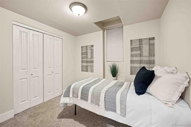 carpeted bedroom with a closet and a textured ceiling