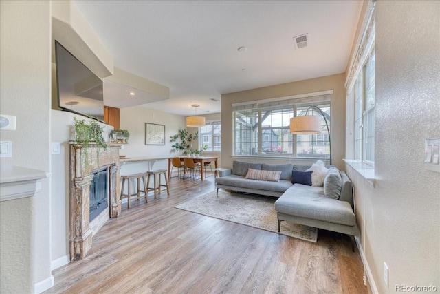 31112 Black Eagle Dr Unit 101, Evergreen, CO 80439 - living area with light wood-style flooring, a glass covered fireplace, and a textured wall