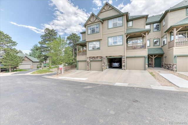 31112 Black Eagle Dr Unit 101, Evergreen, CO 80439 - view of property with an attached garage, stone siding, driveway, and board and batten siding