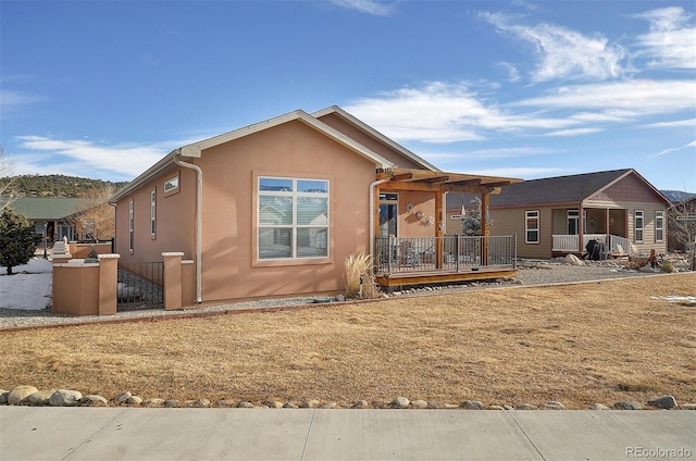 view of front of home featuring stucco siding and a wooden deck