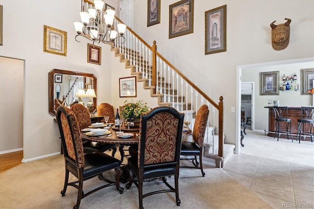 2992 W Long Dr Unit A, Littleton, CO 80120 - carpeted dining space featuring a towering ceiling, stairway, a chandelier, and a dry bar