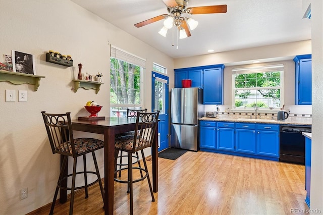 2992 W Long Dr Unit A, Littleton, CO 80120 - kitchen featuring black dishwasher, blue cabinets, freestanding refrigerator, light countertops, and light wood-style flooring